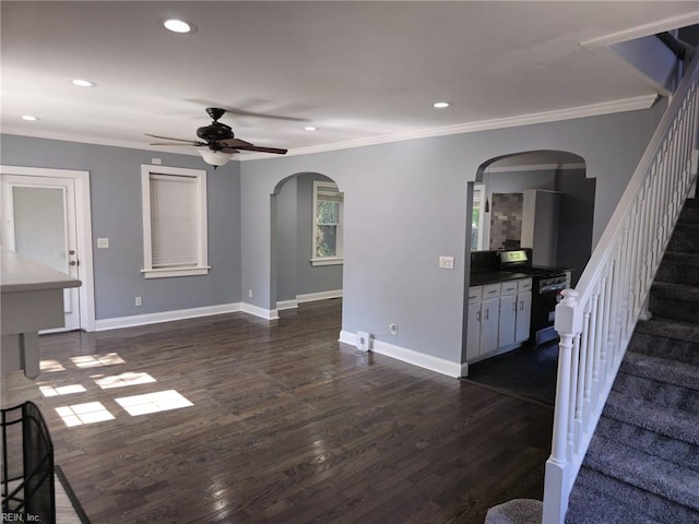 unfurnished living room featuring ceiling fan, dark hardwood / wood-style flooring, and crown molding