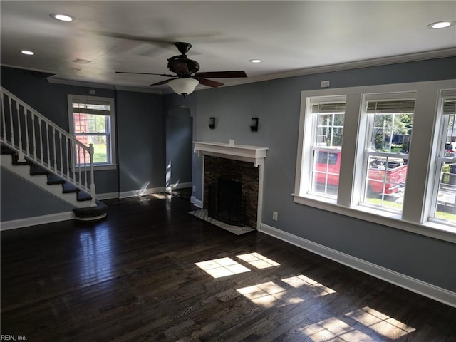 unfurnished living room featuring plenty of natural light, dark wood-type flooring, and ornamental molding