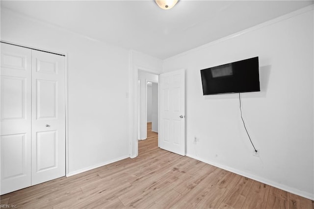 unfurnished bedroom featuring light hardwood / wood-style floors and a closet