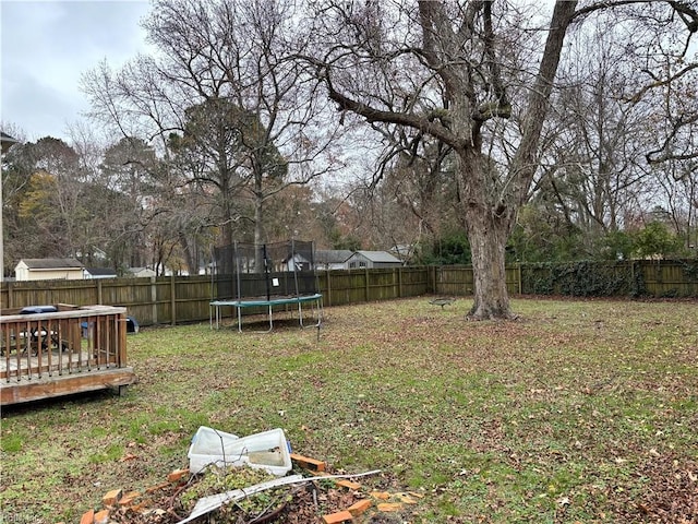 view of yard with a deck and a trampoline