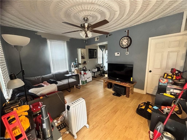 living room featuring ceiling fan, light hardwood / wood-style floors, and radiator