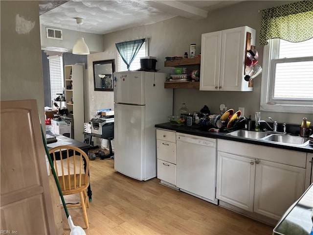 kitchen with sink, light wood-type flooring, white cabinets, hanging light fixtures, and white appliances