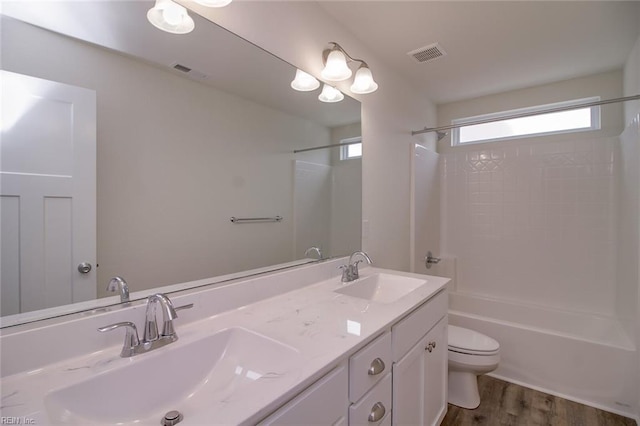 full bathroom featuring hardwood / wood-style flooring, vanity,  shower combination, and toilet