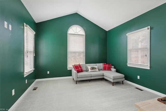 living area featuring carpet, a wealth of natural light, and vaulted ceiling