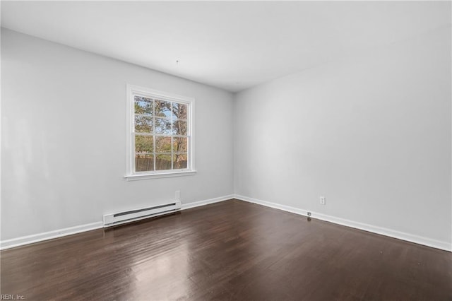 spare room featuring dark hardwood / wood-style floors and a baseboard heating unit