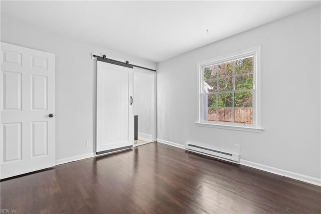 unfurnished bedroom with dark hardwood / wood-style floors, a barn door, and a baseboard heating unit