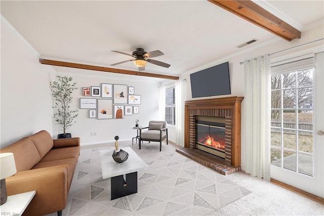 living room featuring beam ceiling, light colored carpet, a brick fireplace, and plenty of natural light