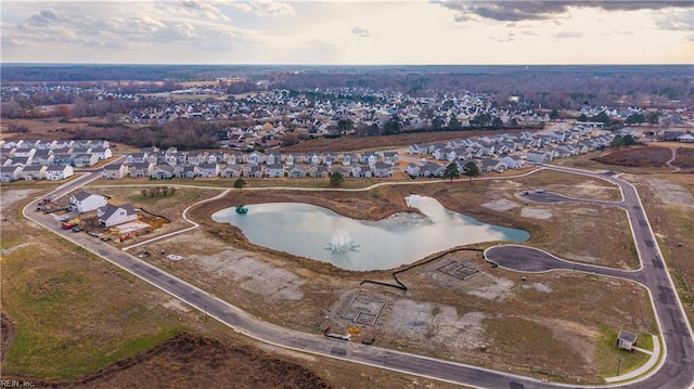 aerial view at dusk featuring a water view