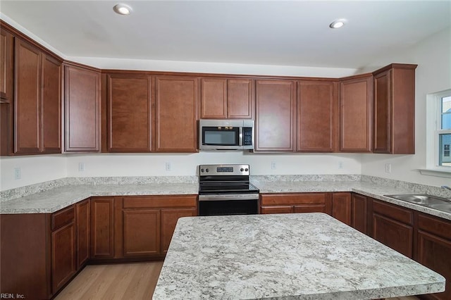 kitchen with sink, light wood-type flooring, and appliances with stainless steel finishes