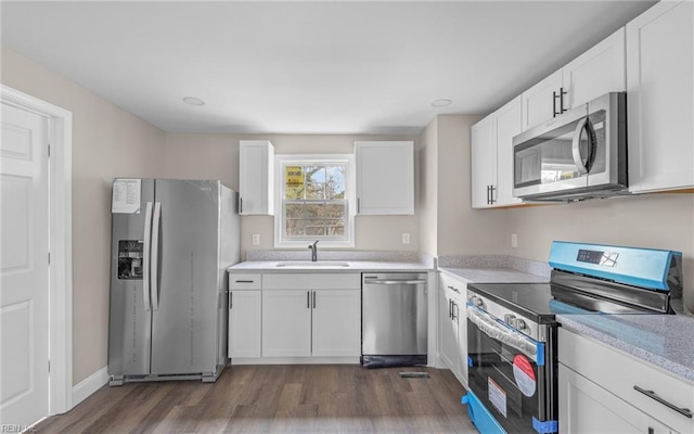 kitchen with white cabinetry, stainless steel appliances, and dark wood-type flooring