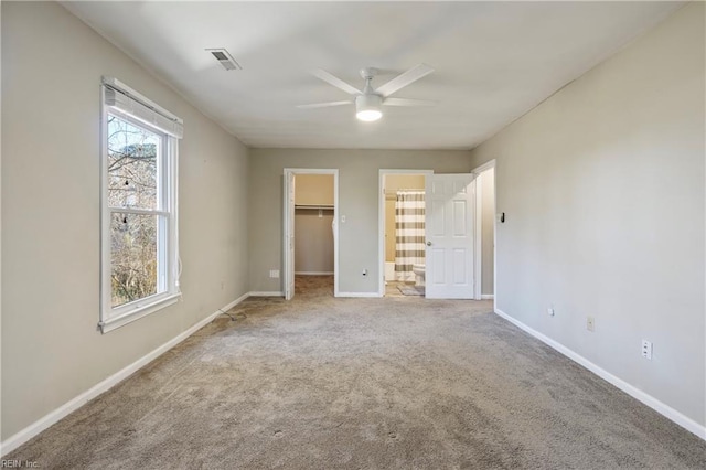 unfurnished bedroom with carpet flooring, ceiling fan, a walk in closet, and a closet