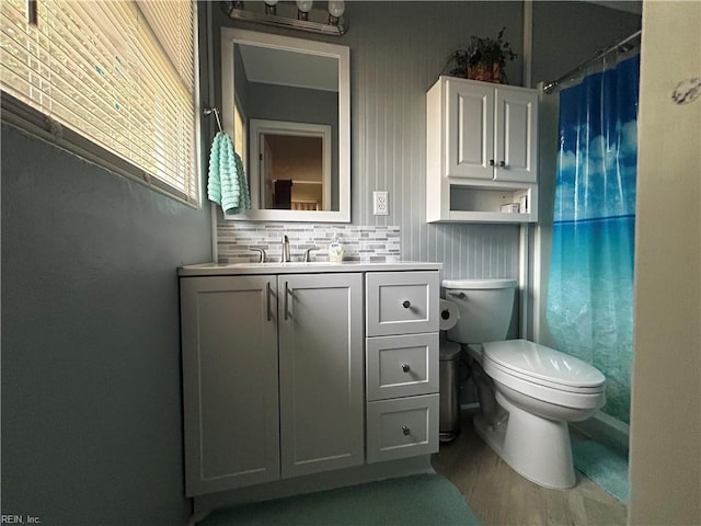 bathroom with curtained shower, backsplash, toilet, vanity, and hardwood / wood-style flooring