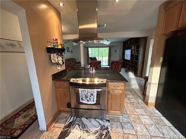 kitchen featuring island range hood, black fridge, stainless steel electric range oven, and dark stone countertops