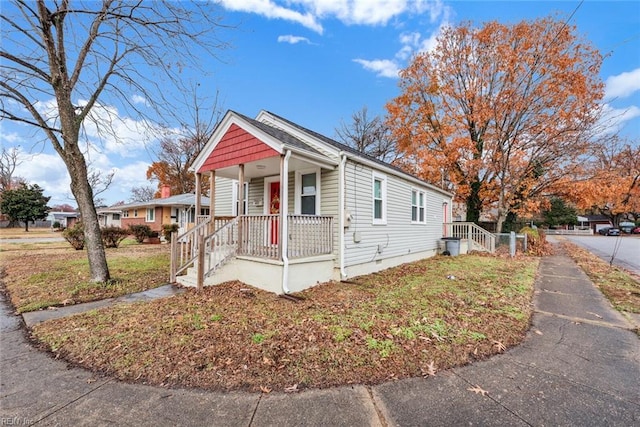 bungalow featuring a porch and a front lawn