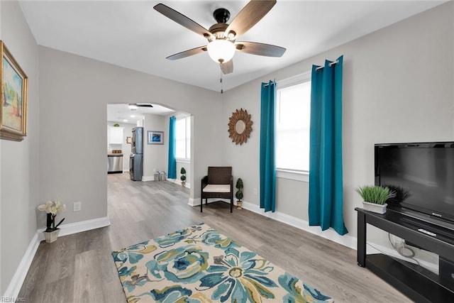 sitting room with light wood-type flooring, a wealth of natural light, and ceiling fan