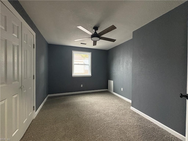 carpeted empty room with a textured ceiling and ceiling fan