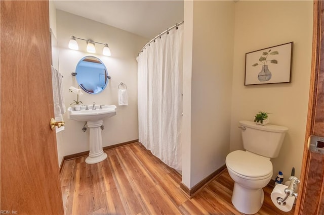 bathroom with hardwood / wood-style flooring and toilet