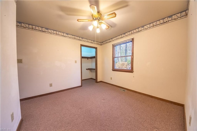 unfurnished room with ceiling fan and light carpet