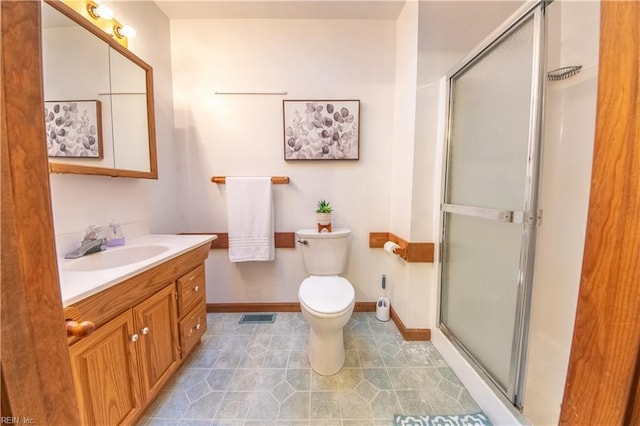 bathroom featuring tile patterned flooring, vanity, an enclosed shower, and toilet