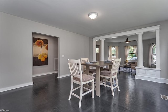 dining room with decorative columns, ceiling fan, and dark hardwood / wood-style floors