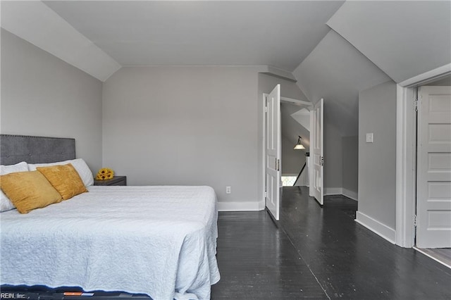 bedroom with dark hardwood / wood-style floors and vaulted ceiling