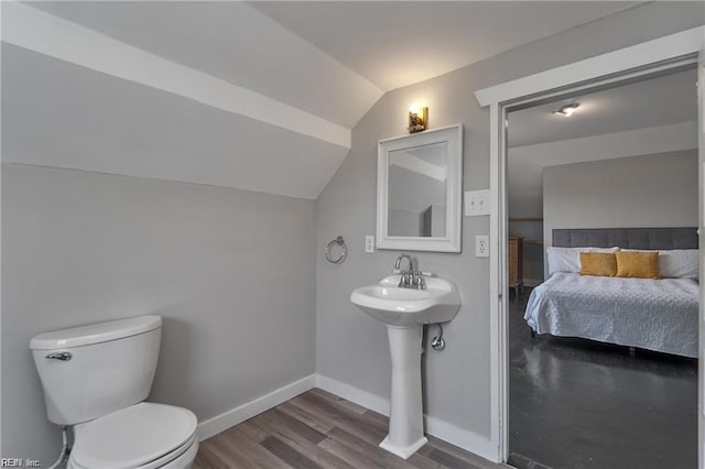 bathroom featuring toilet, vaulted ceiling, and hardwood / wood-style flooring