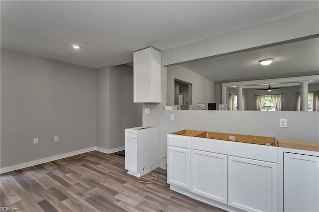 kitchen featuring white cabinets, ceiling fan, and light hardwood / wood-style flooring