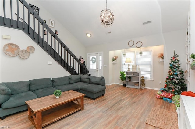 living room with light hardwood / wood-style flooring and a notable chandelier