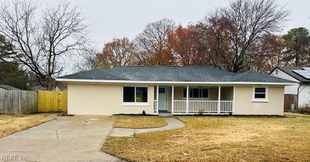 ranch-style house featuring covered porch and a front yard