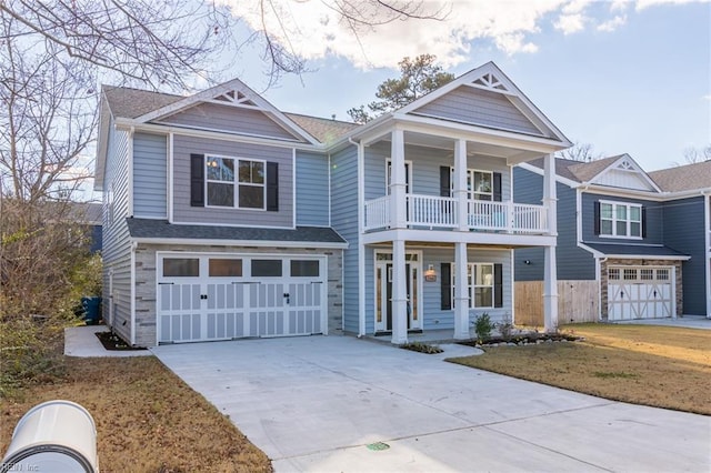 view of front of house featuring covered porch, a garage, and a front lawn