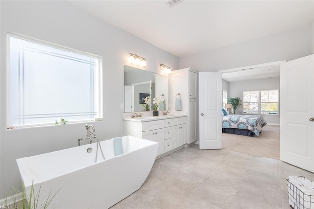 bathroom with a washtub and vanity