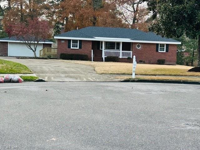 single story home with a porch, a garage, and an outdoor structure