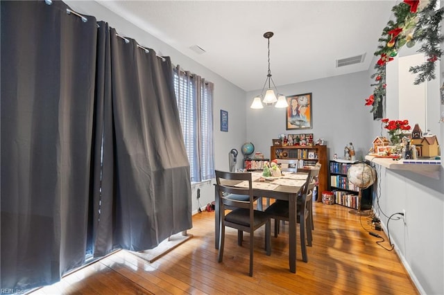 dining room with light hardwood / wood-style flooring and a chandelier