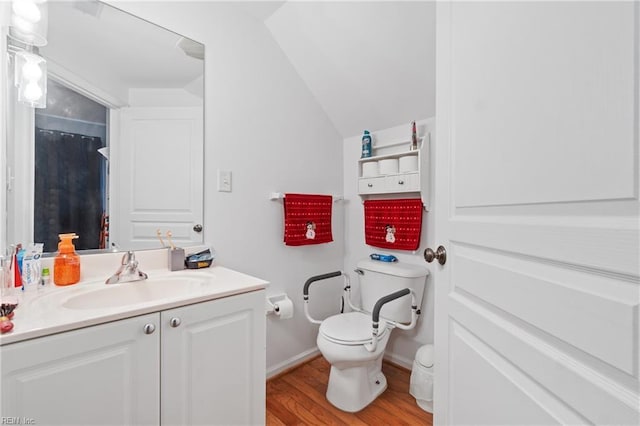 bathroom with hardwood / wood-style flooring, vanity, toilet, and lofted ceiling