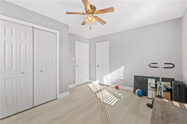 exercise area featuring ceiling fan and light hardwood / wood-style flooring