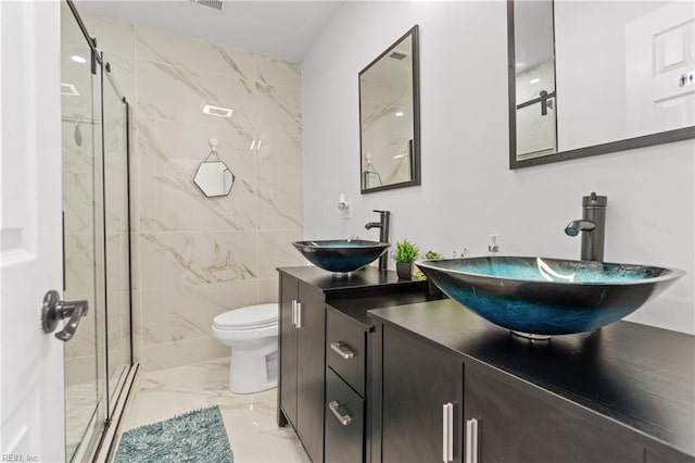 bathroom featuring vanity, a shower with shower door, tile walls, and toilet