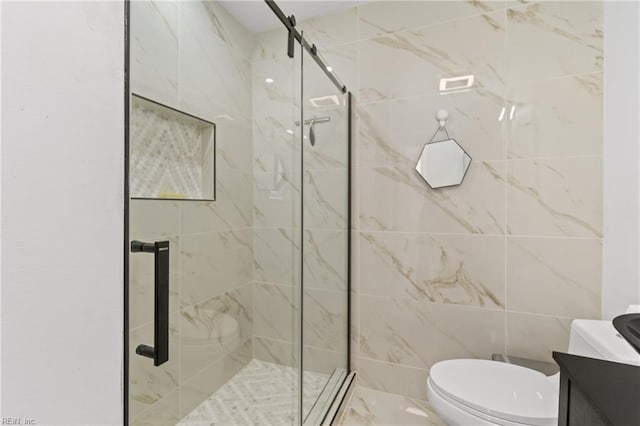 bathroom with a shower with door, vanity, tile walls, and toilet