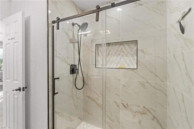 bathroom with a shower with door