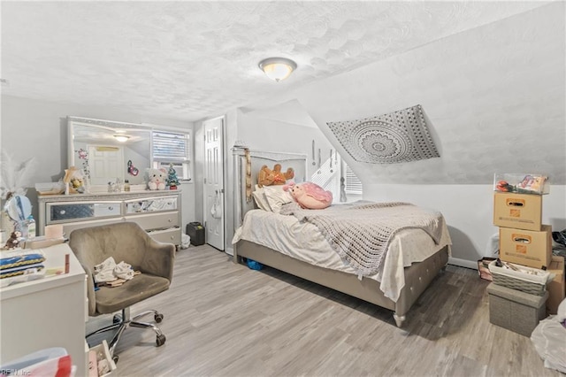 bedroom with a textured ceiling and light wood-type flooring