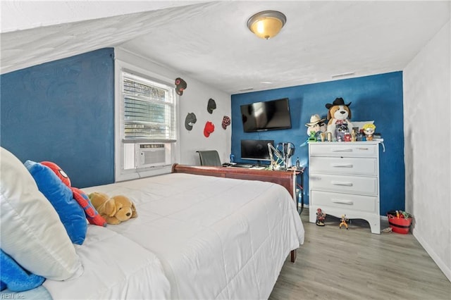 bedroom with light hardwood / wood-style floors and cooling unit