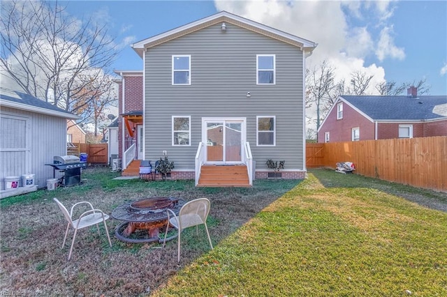 back of house featuring a yard and a fire pit