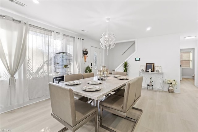 dining space featuring an inviting chandelier, light hardwood / wood-style flooring, and a wealth of natural light