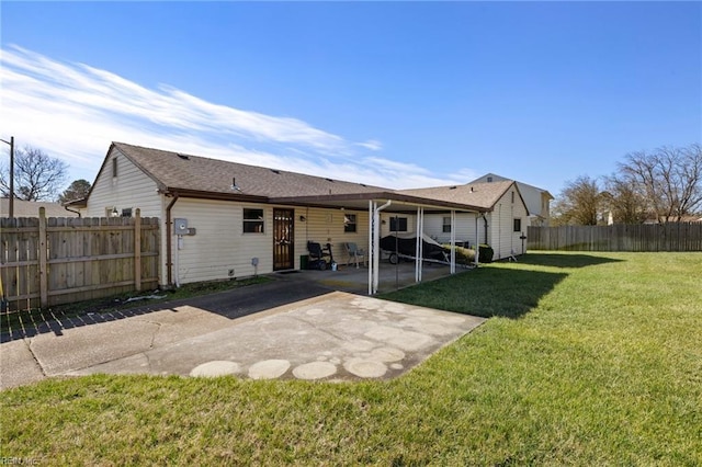 back of house featuring a patio area and a lawn