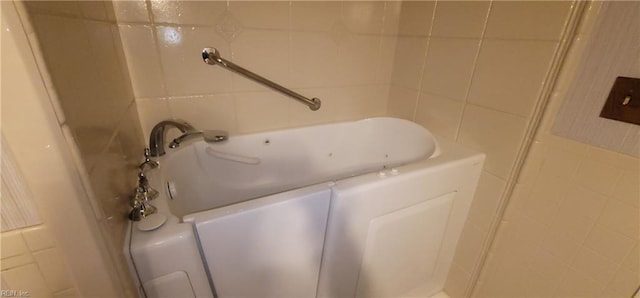 bathroom featuring tile walls and a washtub