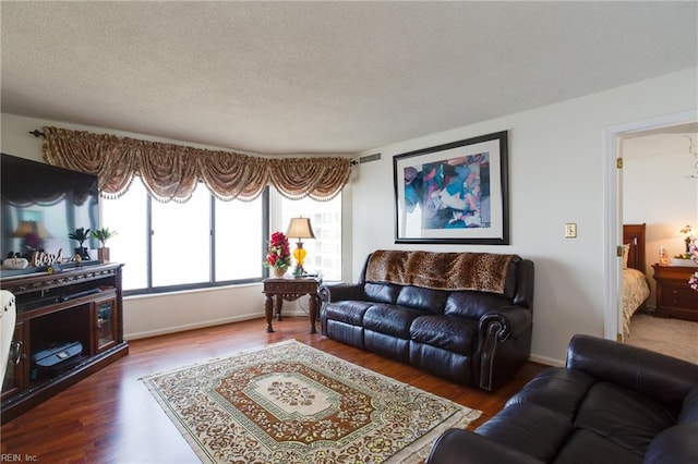 living room with dark hardwood / wood-style flooring and a textured ceiling