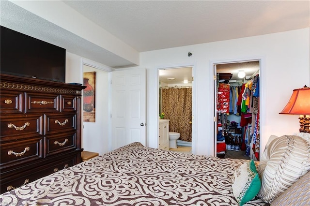 bedroom featuring ensuite bath, a closet, and a spacious closet