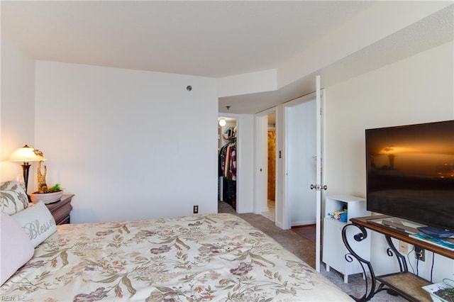 bedroom featuring a closet, a spacious closet, and light carpet