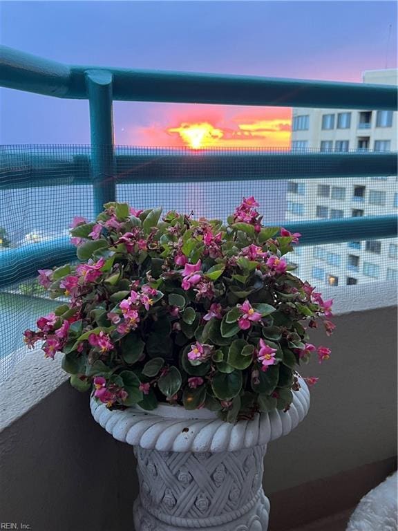 balcony at dusk featuring a water view