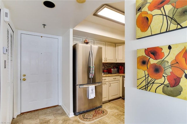 kitchen featuring stainless steel fridge and backsplash