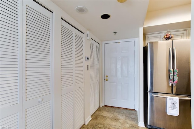 kitchen with stainless steel fridge and white cabinetry